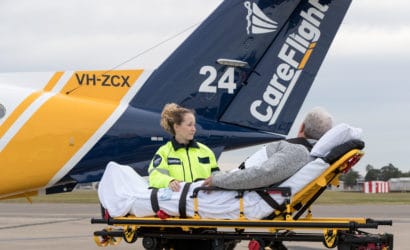 CareFlight nurse helps transfer patient to CareFlight aeroplane