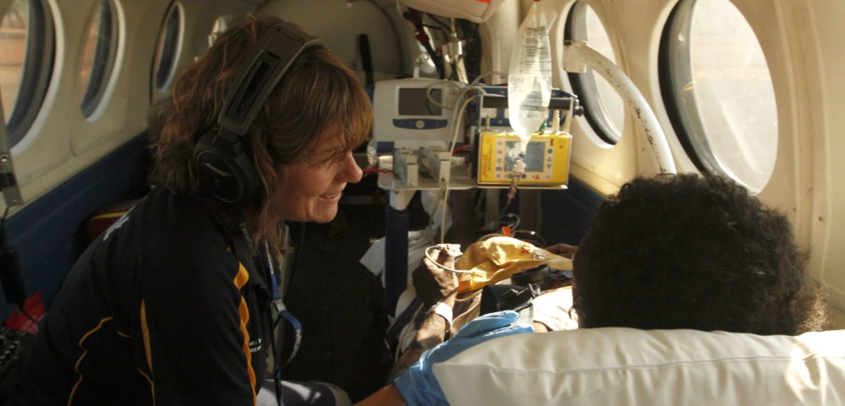 CareFlight nurse treating an indigenous patient while transferring in turbo prop plane